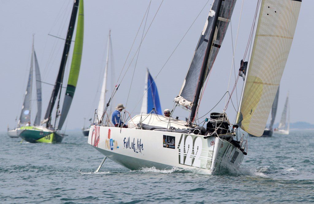A sailing regatta featuring a white Class 40 sailboat with 'Croatia Full of Life' written on its side, co-skippered by Ivica Kostelić, racing on a blue sea towards their 2018 victory.