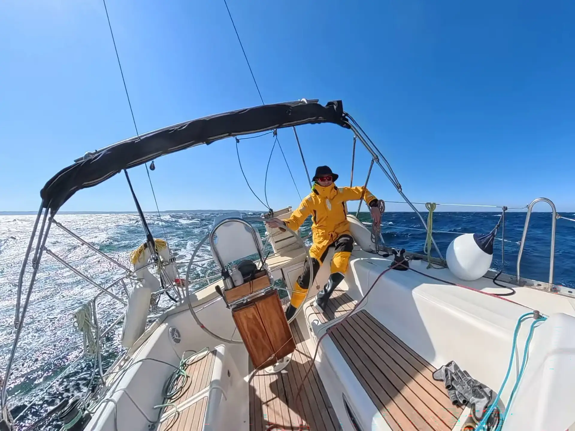Skipper at the helm in foul weather gear during open Adriatic passage