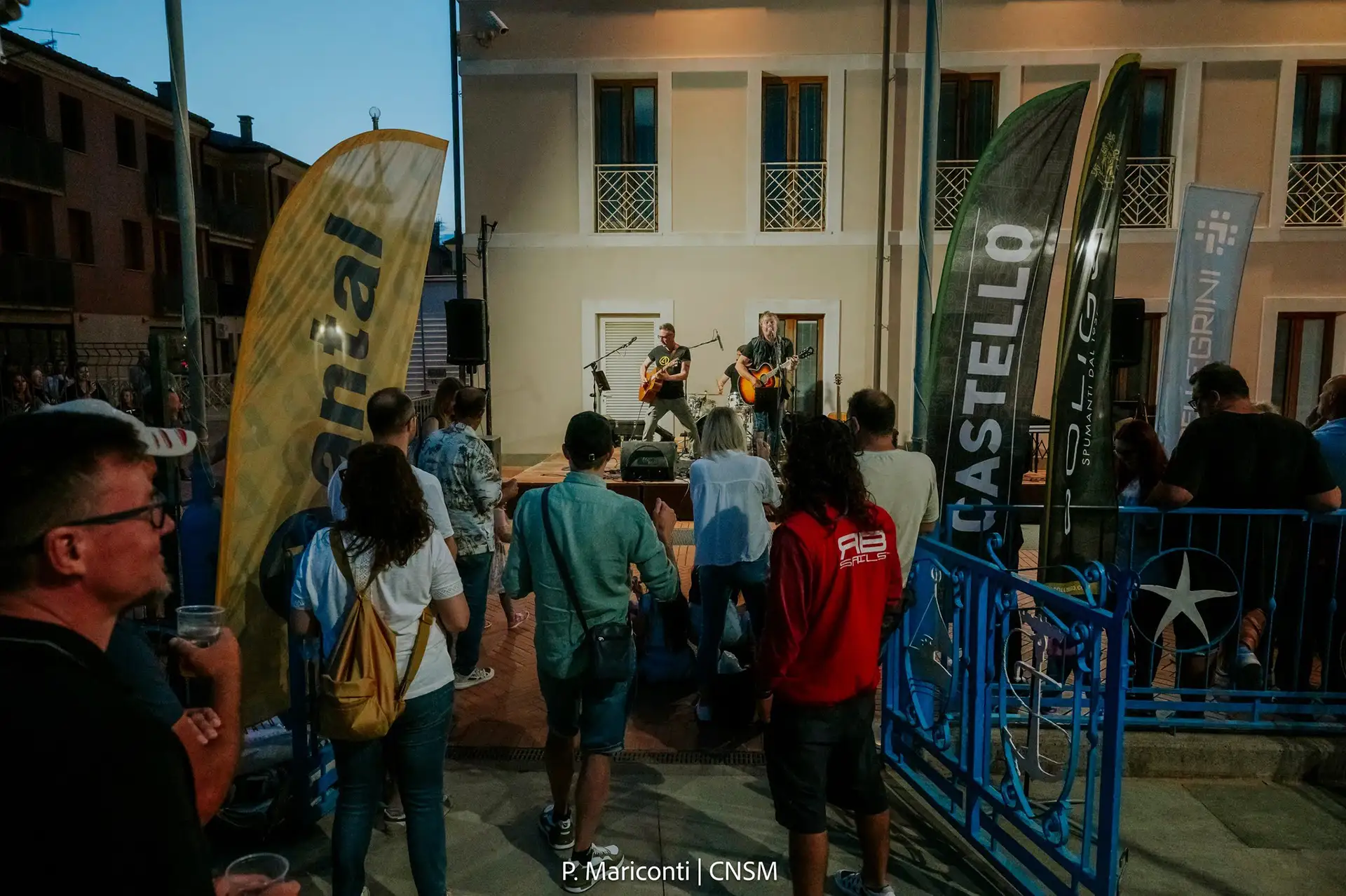 Pre-regatta festivities in Caorle, featuring live music and a gathering of sailors and locals in the town square.